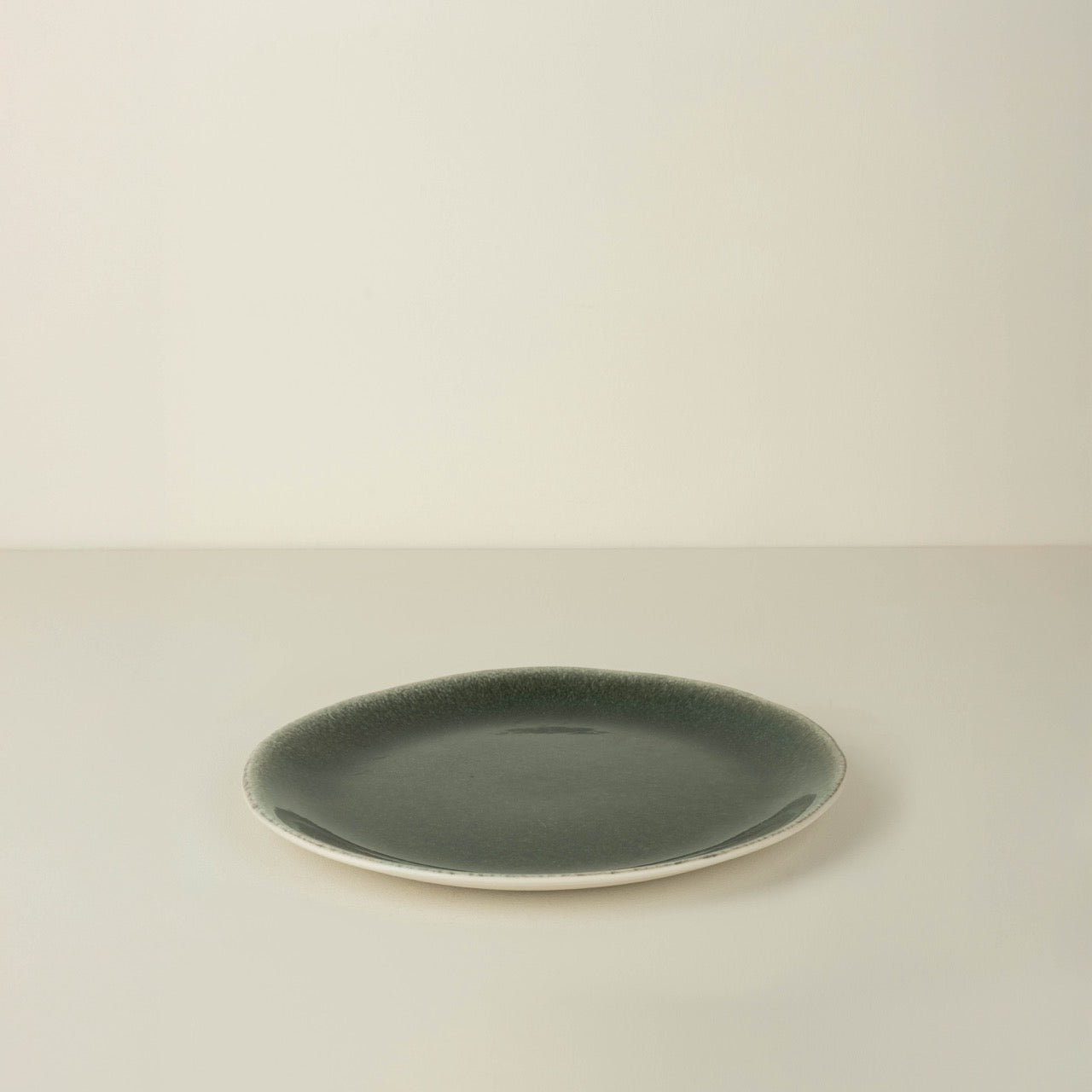 Green ceramic plate on a beige background