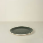 Green ceramic plate on a beige background
