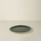 Green ceramic plate on a beige background