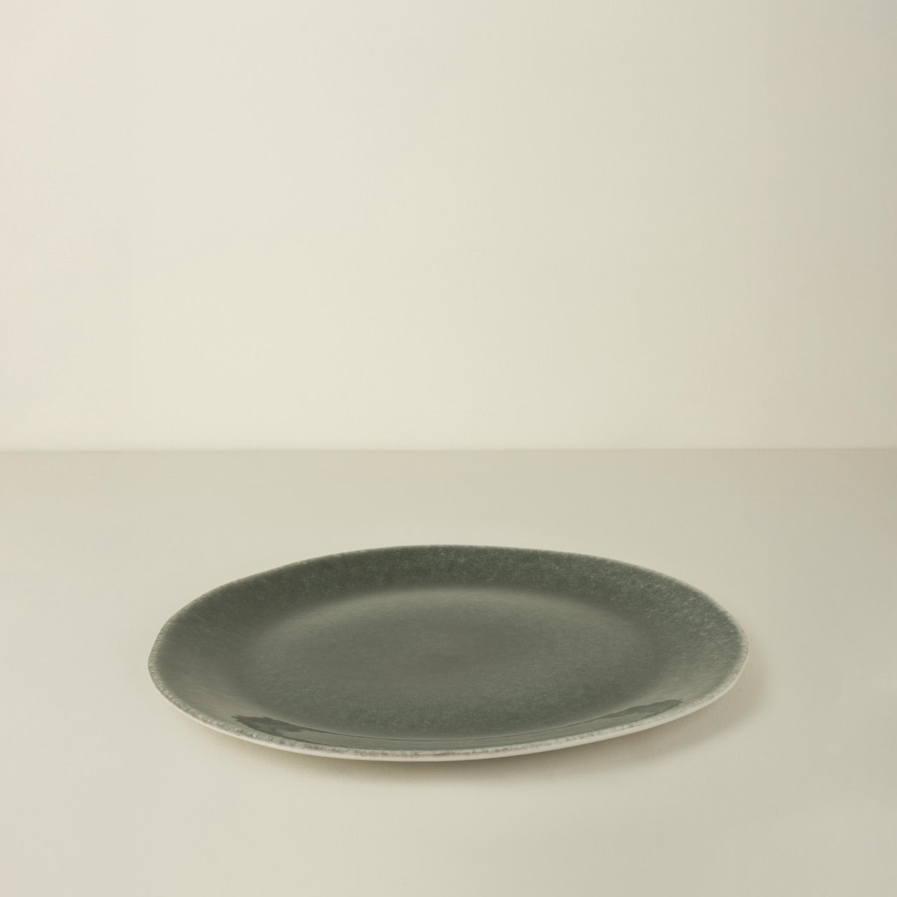 Green ceramic plate on a beige background
