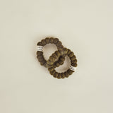 Two brown textured bracelets on a beige background