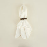 White scarf with a wooden clip on a beige background