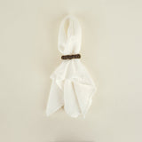 White scarf with a wooden clip on a beige background