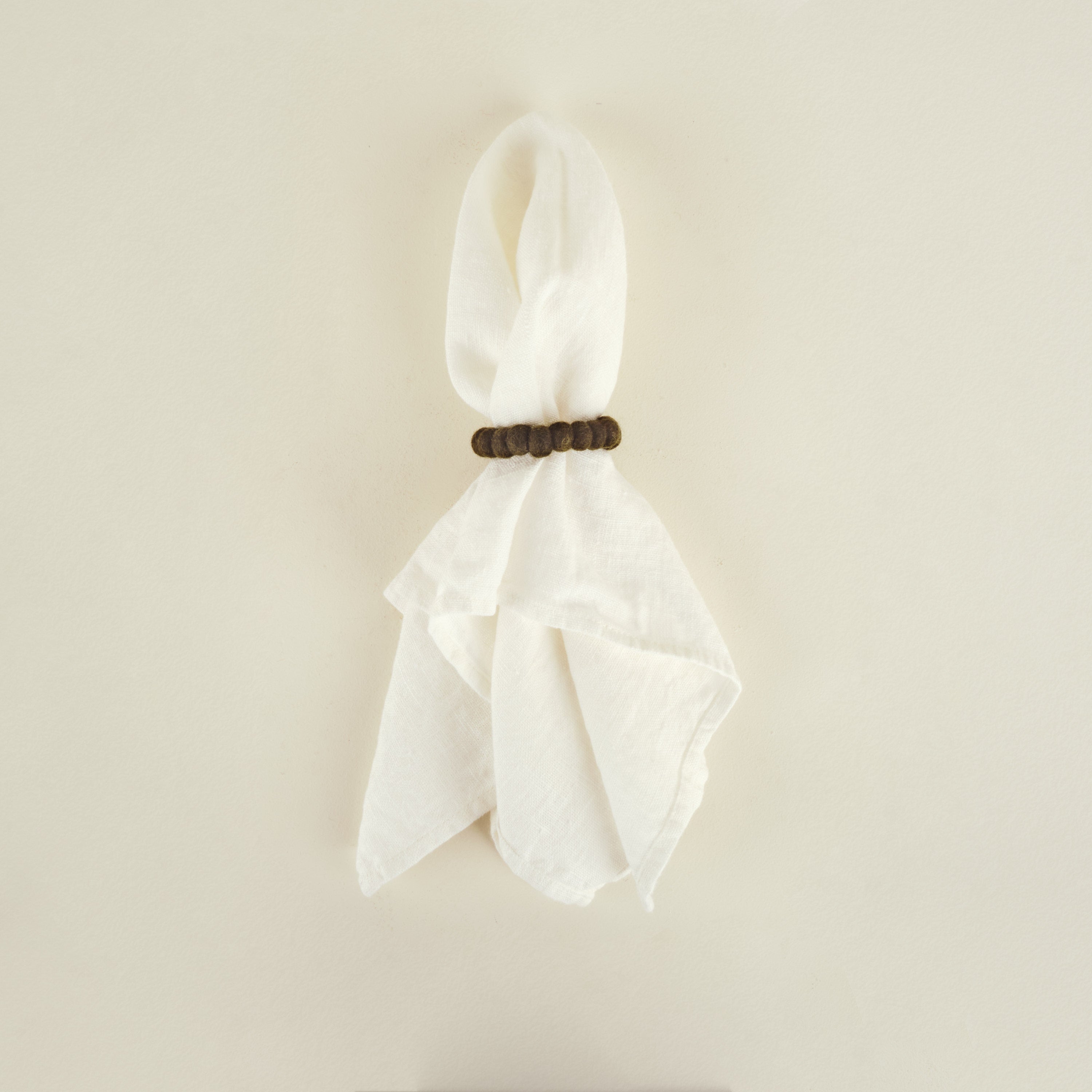 White scarf with a wooden clip on a beige background