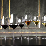 Row of wine glasses with different types of wine on a dark surface with decorative background