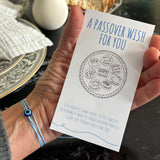 Hand holding a Passover wish card with a decorative background