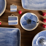 Ceramic tableware with blue floral designs on a wooden surface.