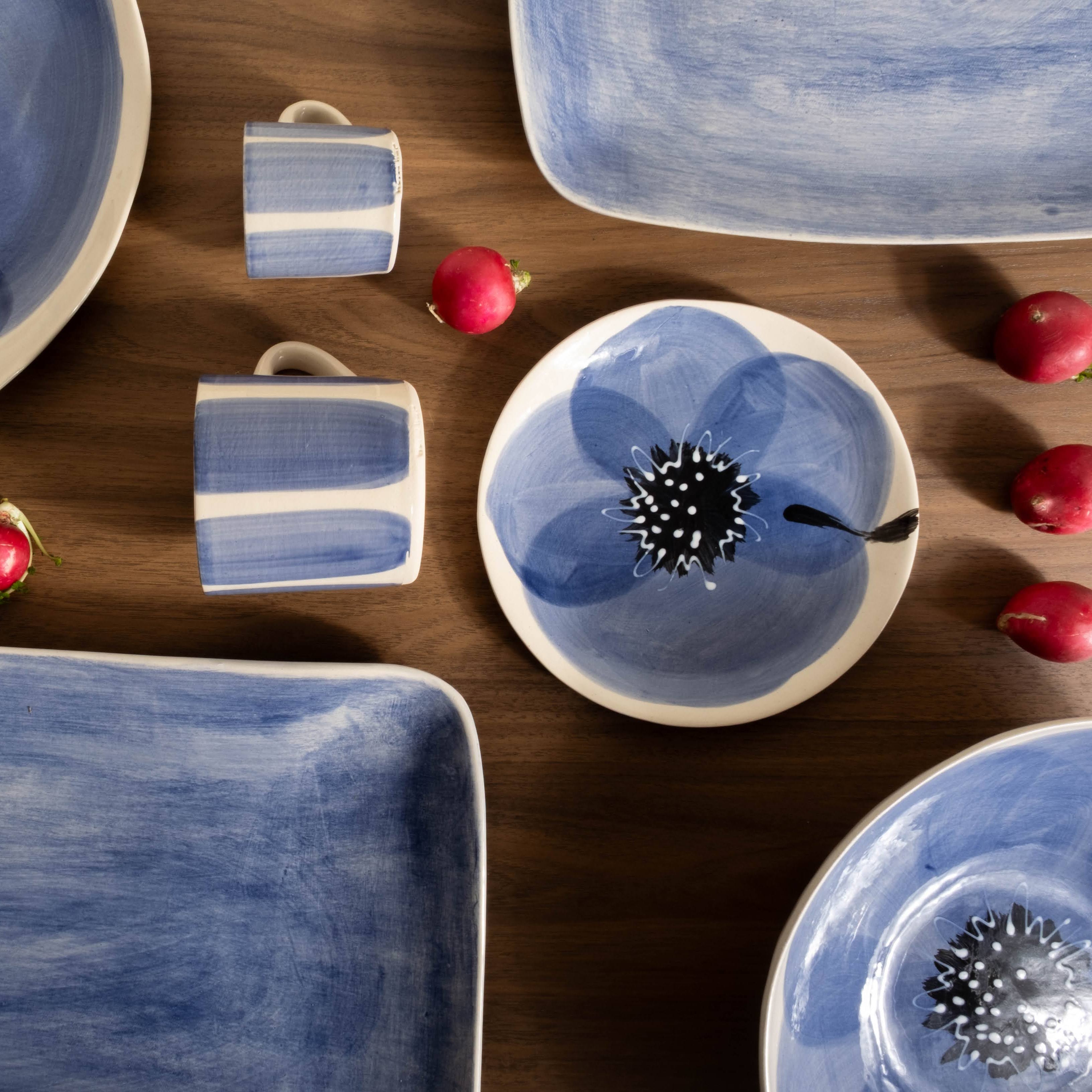 Ceramic tableware with blue floral designs on a wooden surface.