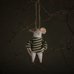 Decorative mouse ornament in a striped sweater hanging from a branch against a dark background