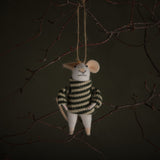 Decorative mouse ornament in a striped sweater hanging from a branch against a dark background