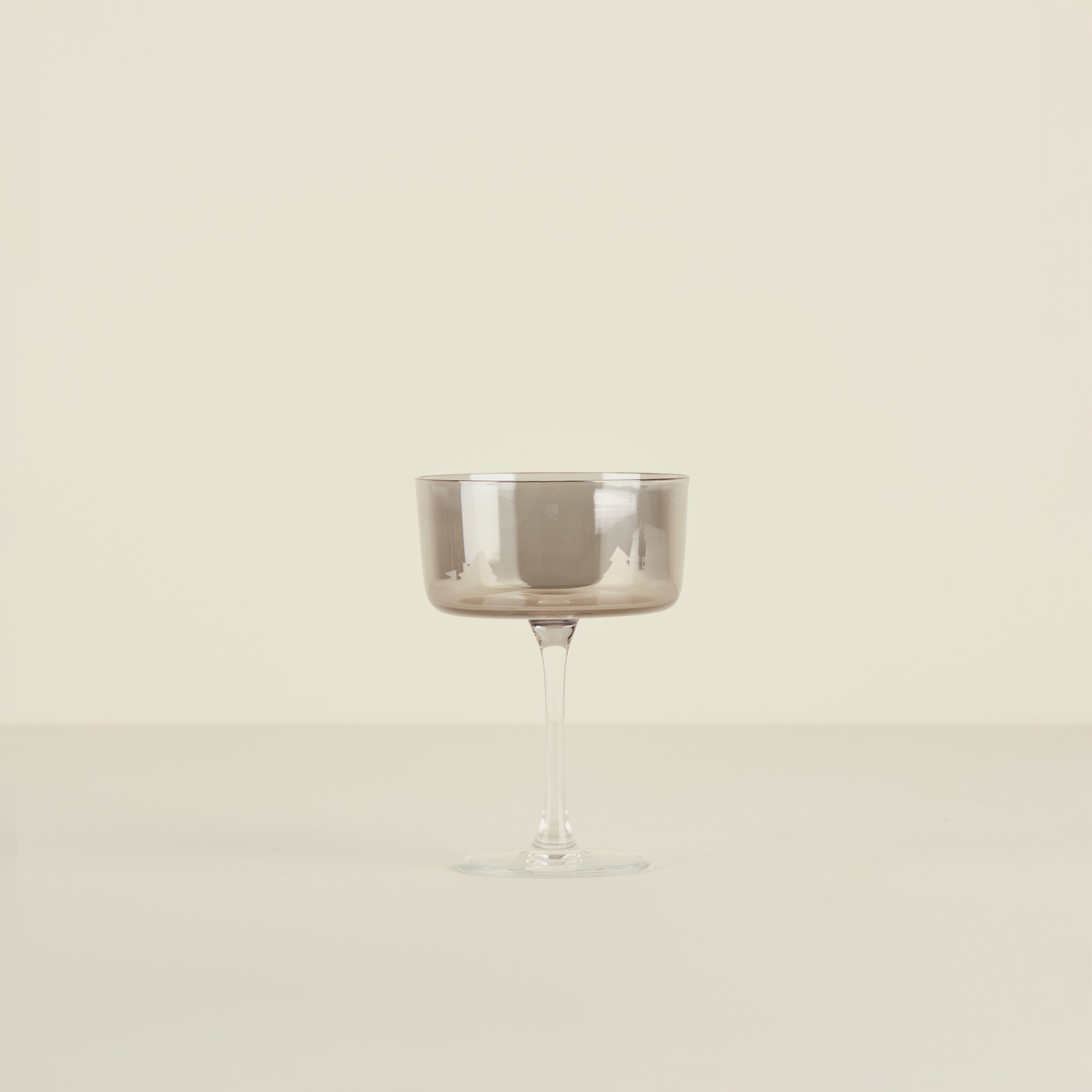 Silver coupe glass on a beige background