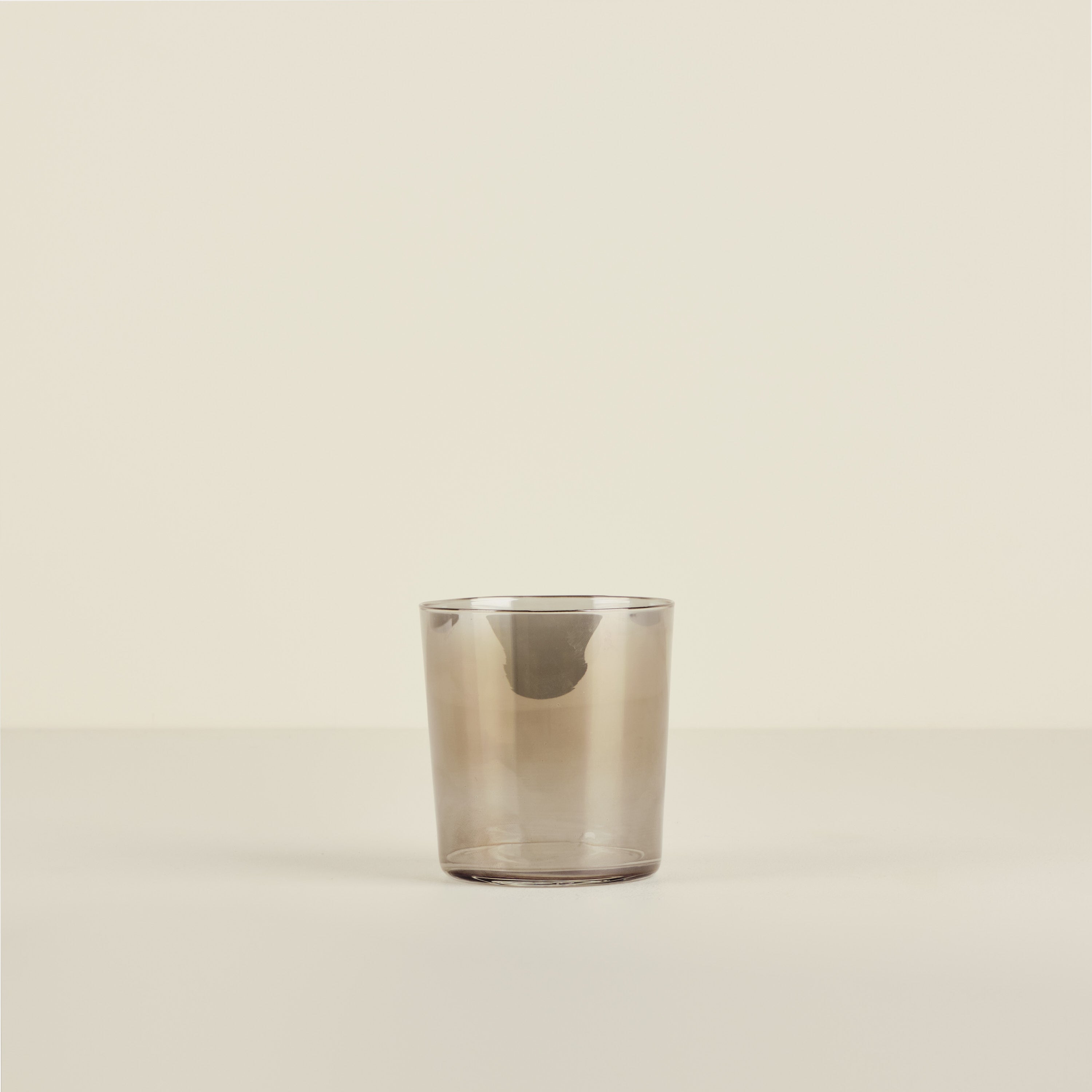 Clear glass tumbler on a beige background