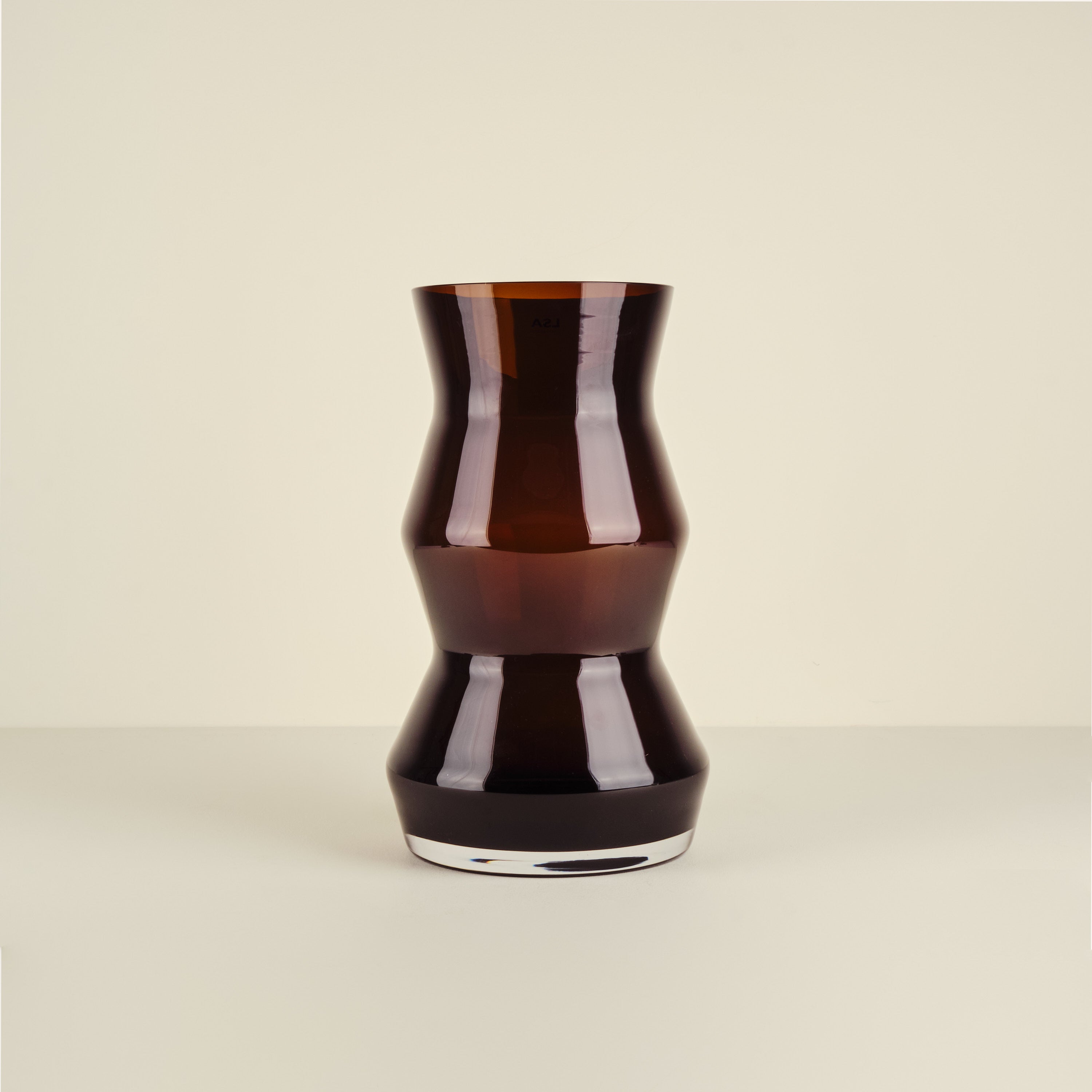Black glass vase on a beige background