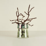 Glass vase with dark branches on a light background