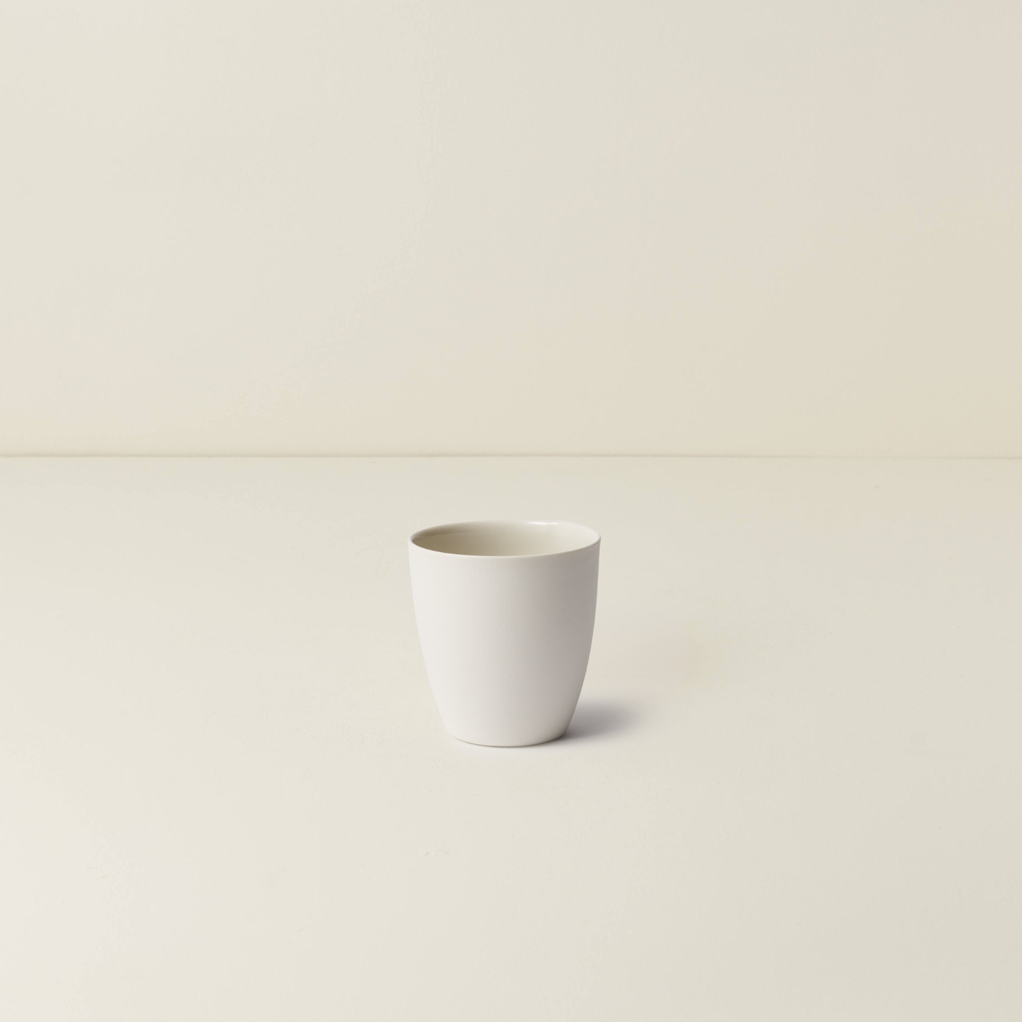 White ceramic cup on a beige background