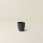 Black ceramic cup on a beige background