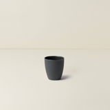 Black ceramic cup on a beige background