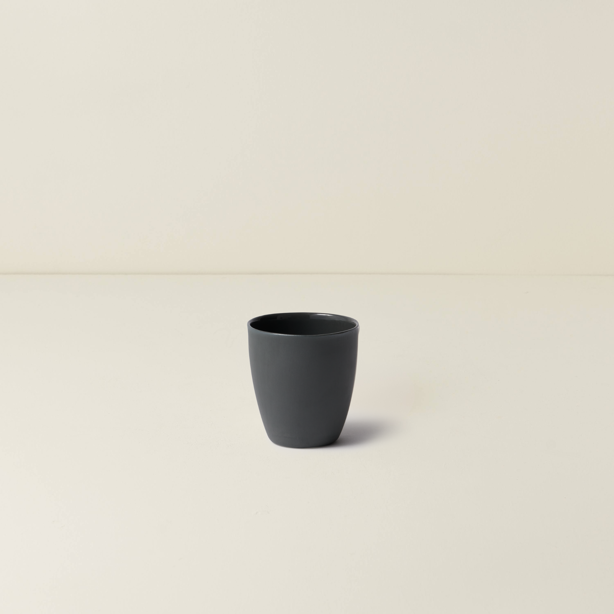 Black ceramic cup on a beige background