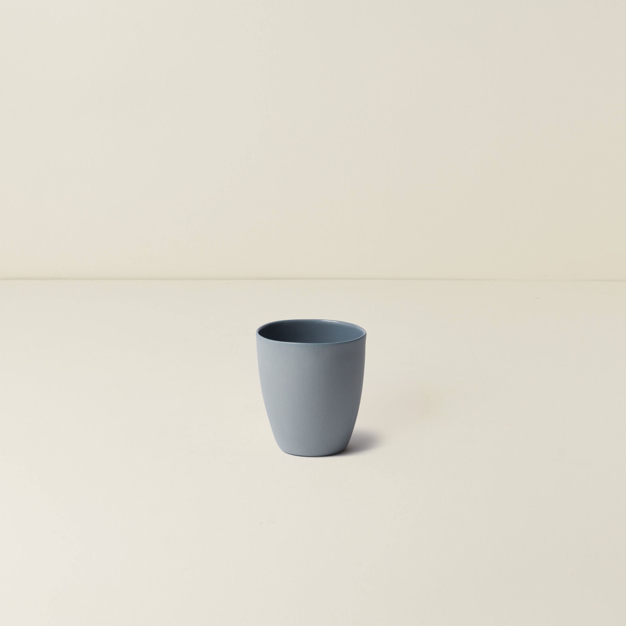Blue ceramic cup on a beige background