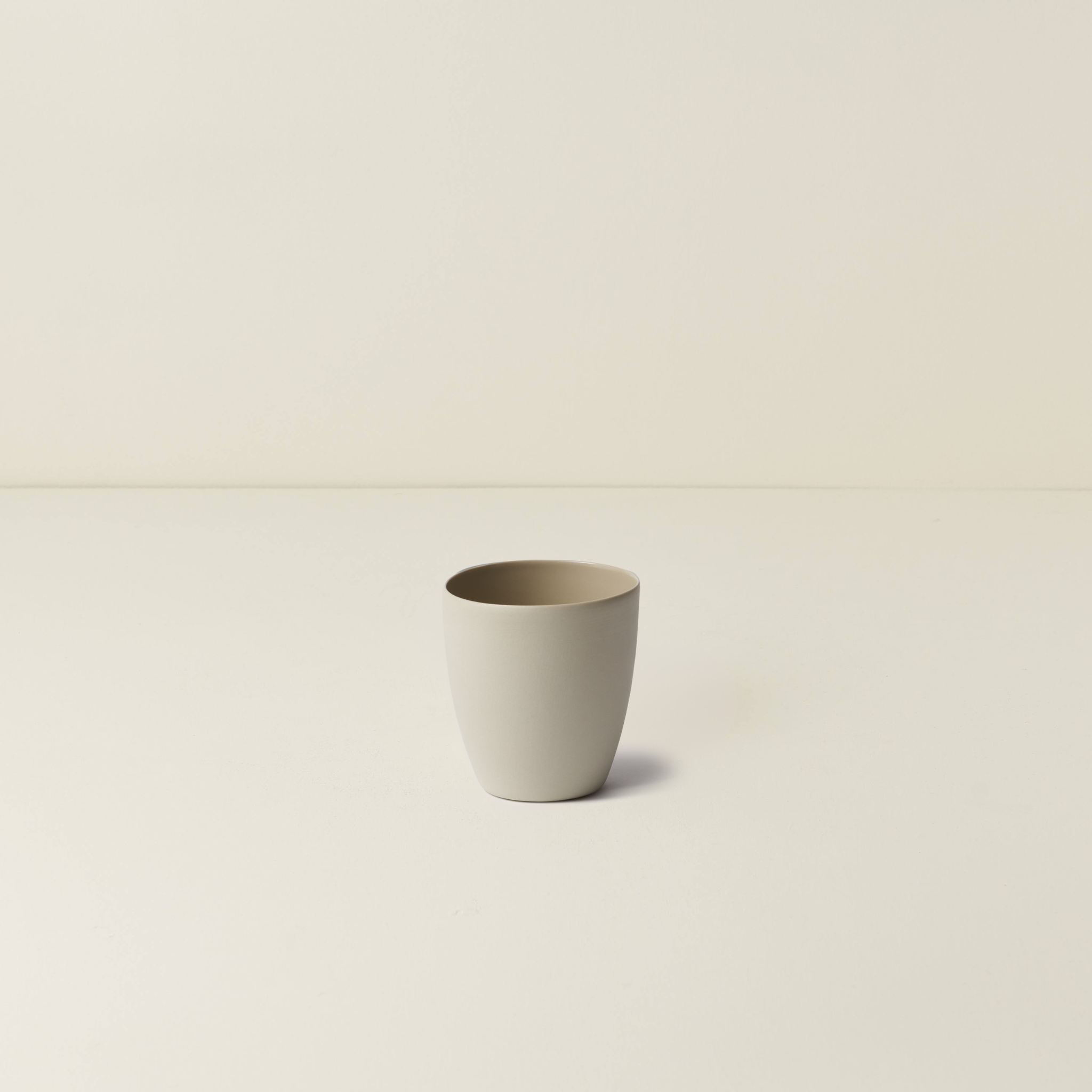 Beige ceramic cup on a beige background