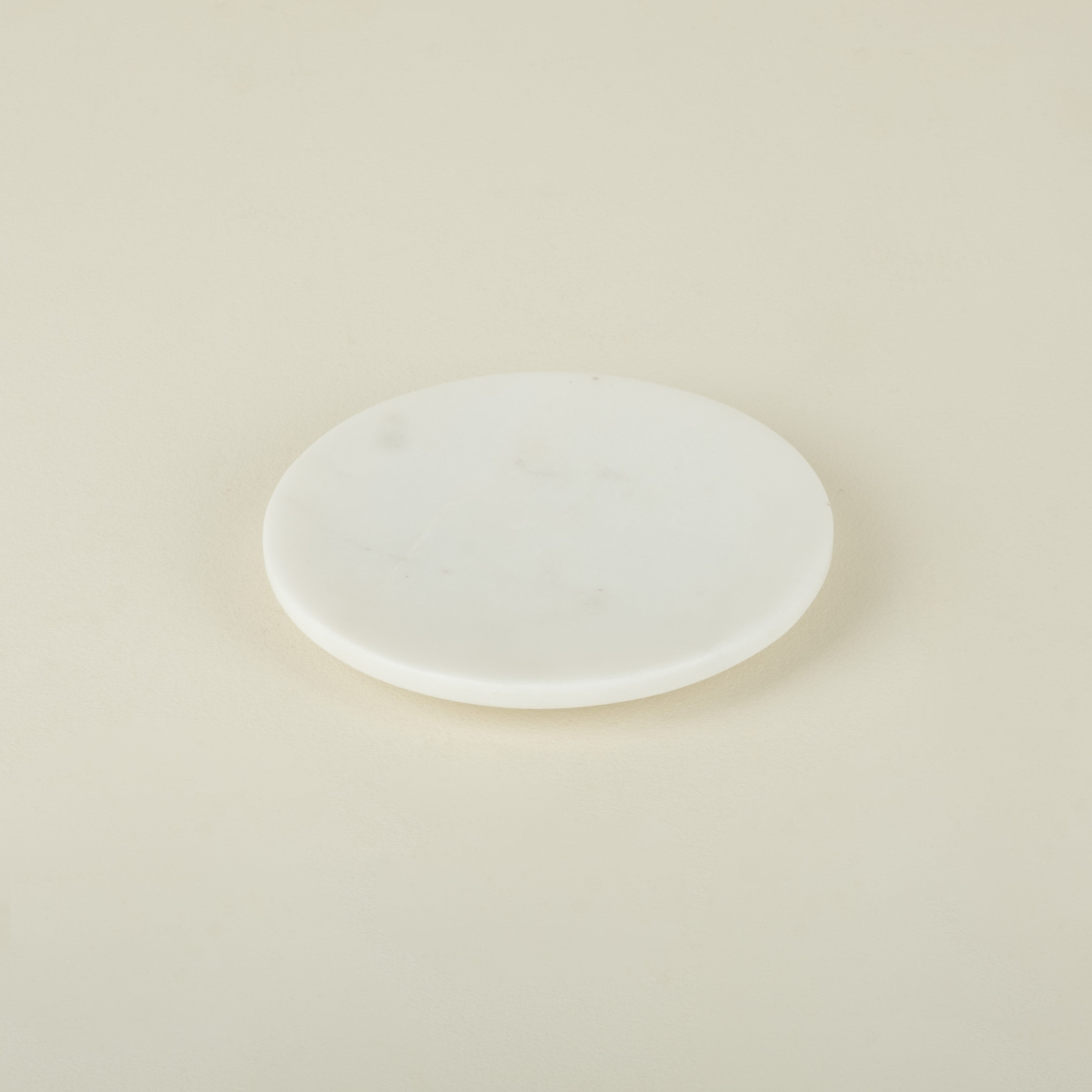 White marble plate on a beige background