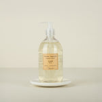 Bottle of liquid soap labeled 'Lait' on a marble plate with beige background