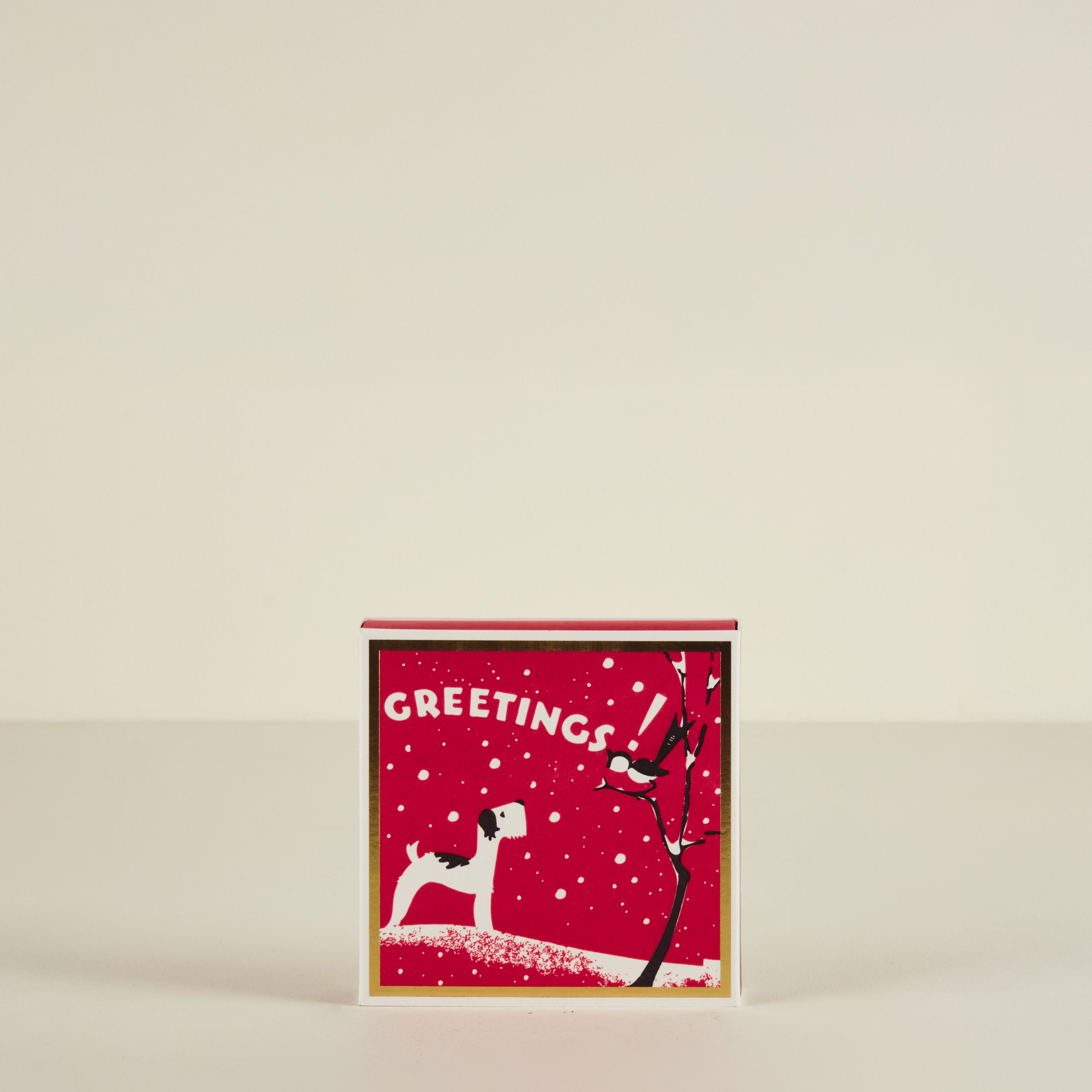 Red greeting card with a dog and tree design on a beige background