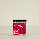 Matchbox with Christmas design featuring a dog and tree on a red background