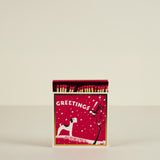 Matchbox with Christmas design featuring a dog and tree on a red background
