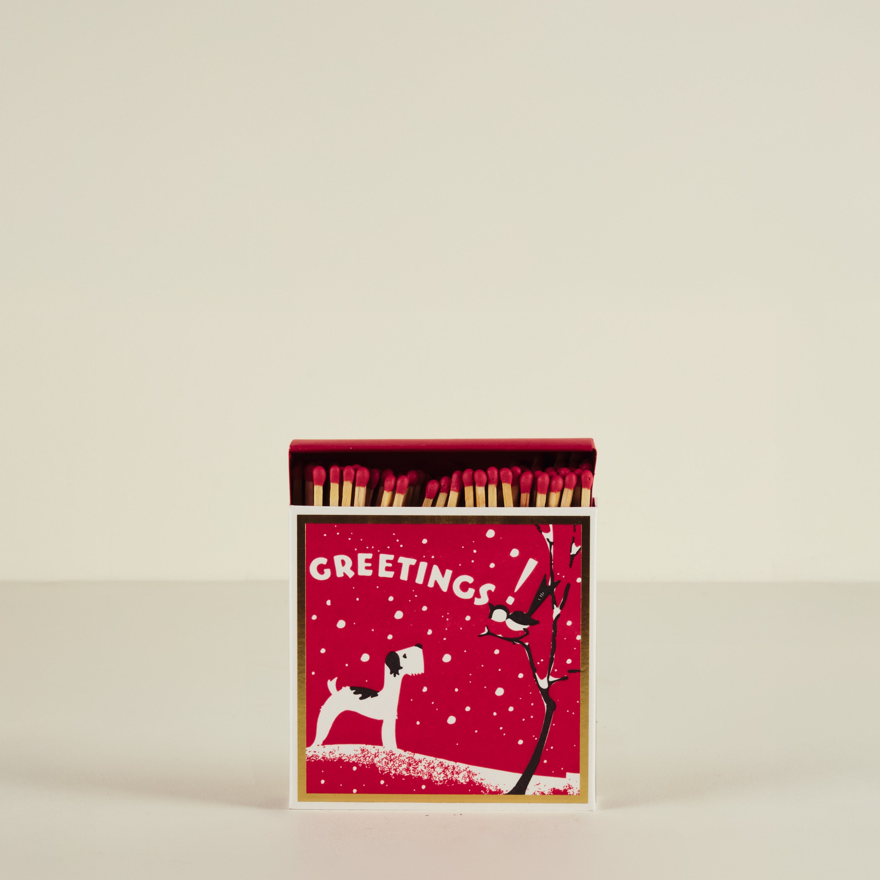 Matchbox with Christmas design featuring a dog and tree on a red background