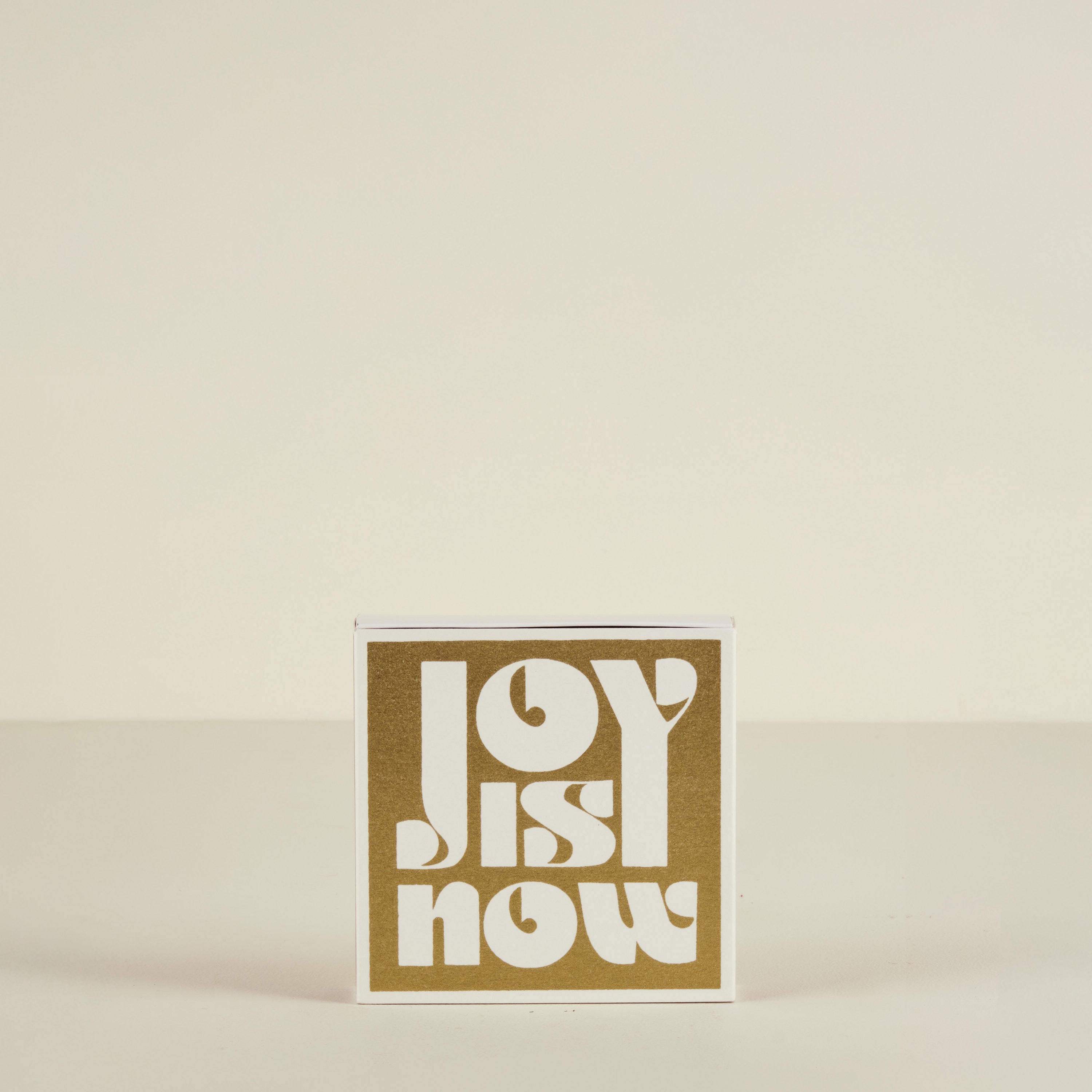 Card with 'Joy is Now' text on a beige background