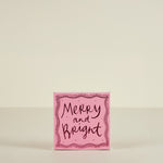 Pink card with 'Merry and Bright' text on a beige background