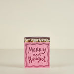 Matchbox with 'Merry and Bright' text on a beige background