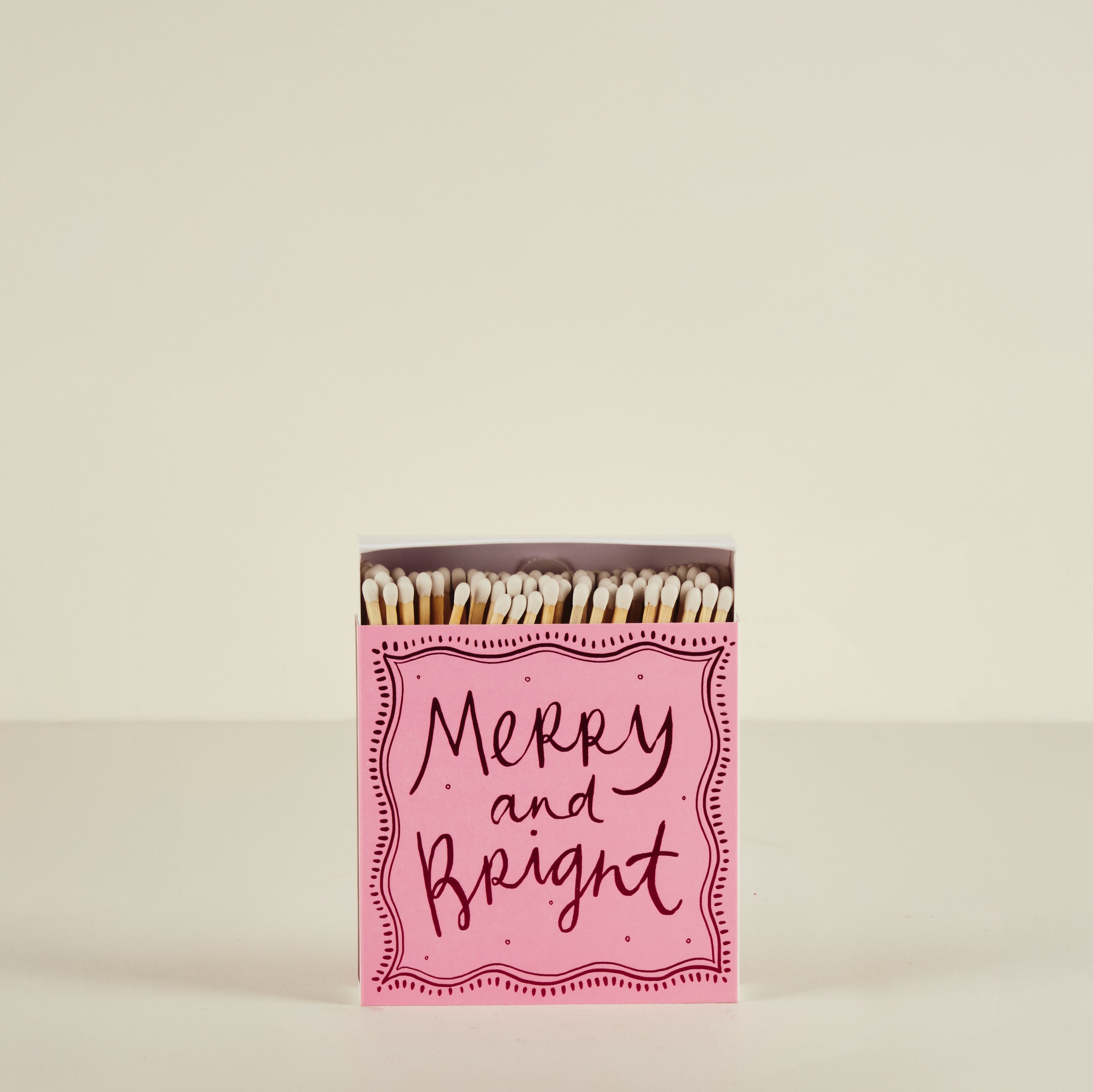 Matchbox with 'Merry and Bright' text on a beige background