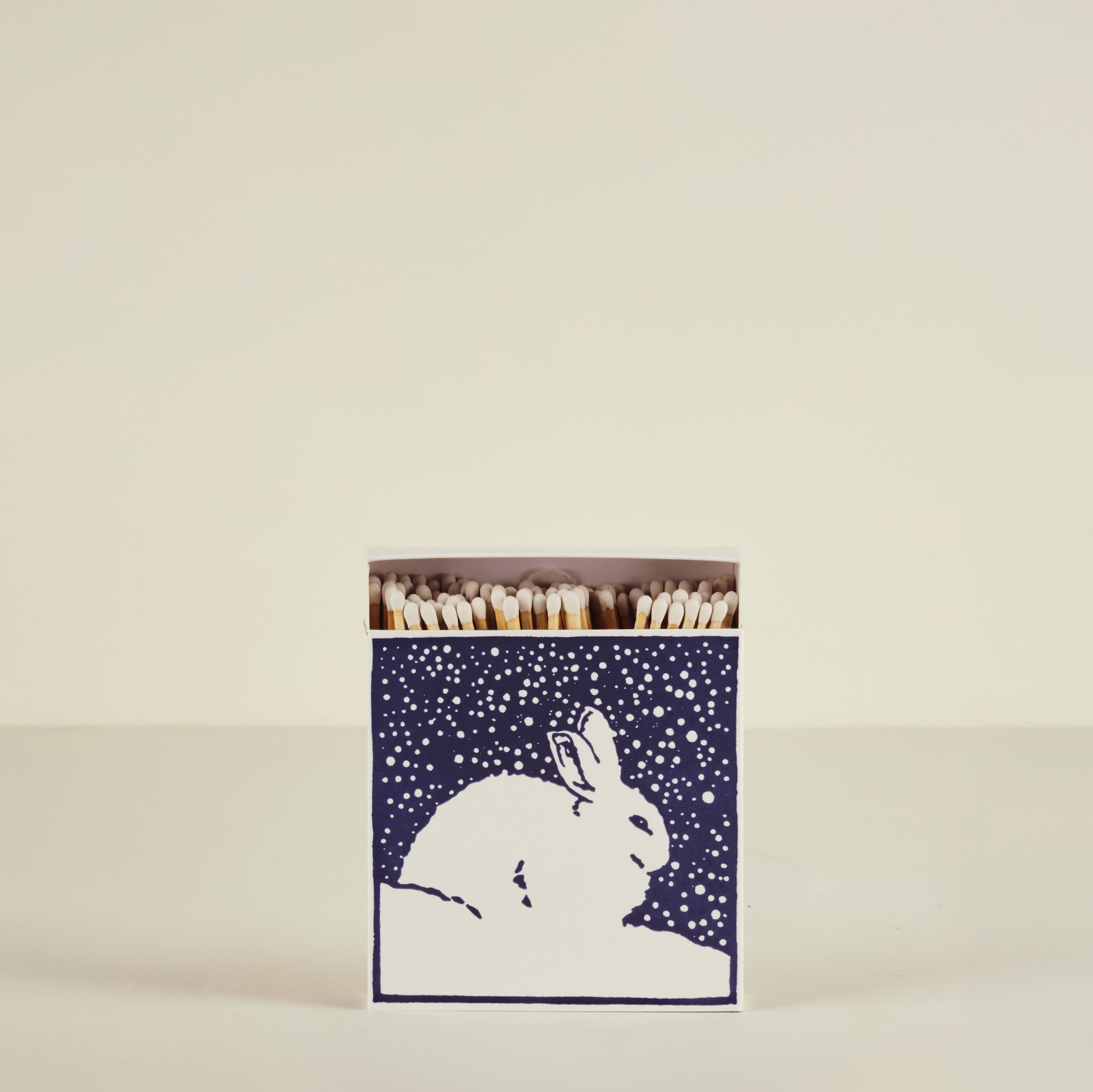 Matches in a box with a rabbit design on a beige background