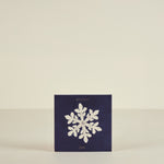 Navy blue card with a white snowflake and 'winter joy' text on a beige background