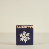 Matchbox with snowflake design and 'winter joy' text on a beige background