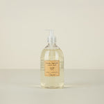 Bottle of liquid soap with a label on a beige background