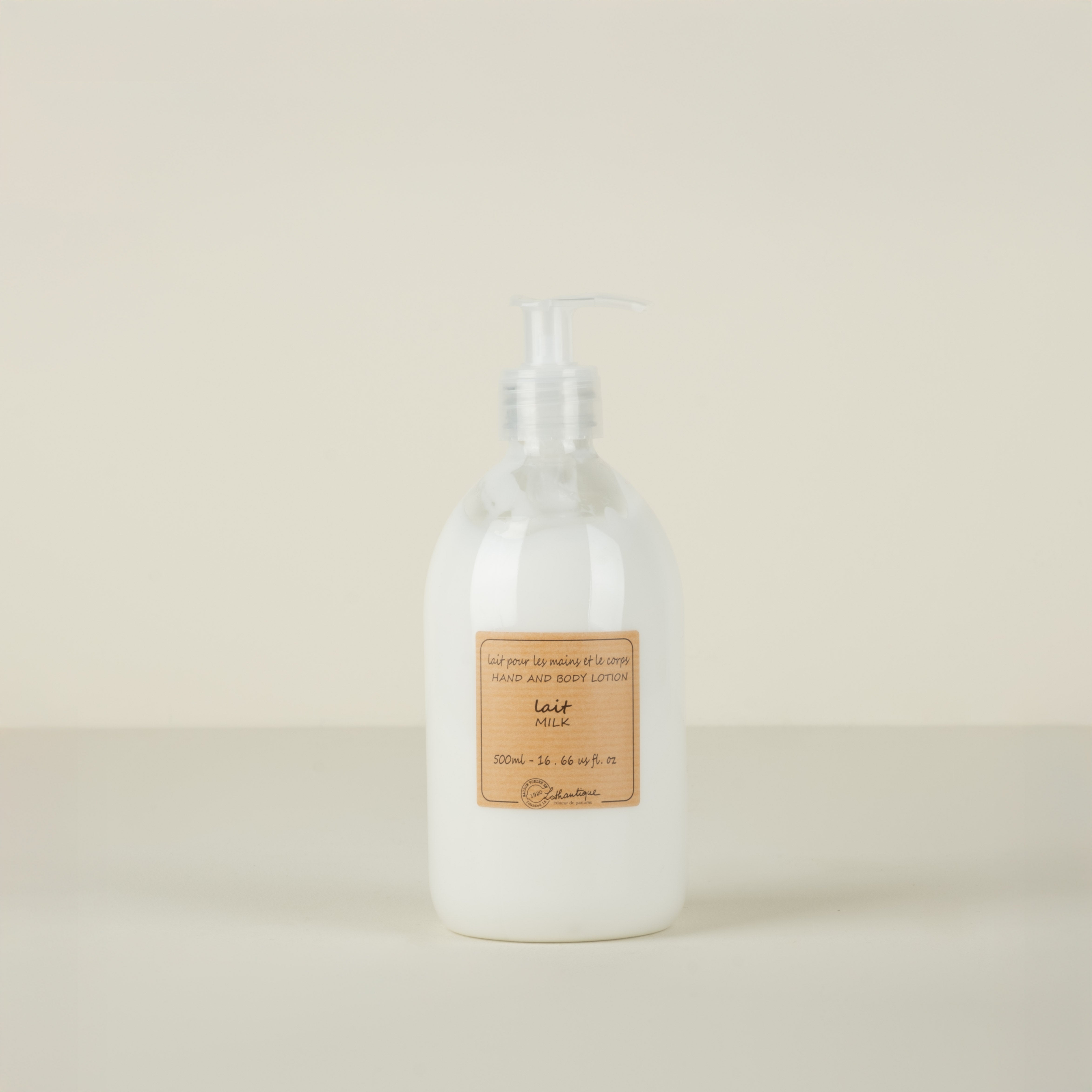 White lotion bottle with a pump and a label on a beige background