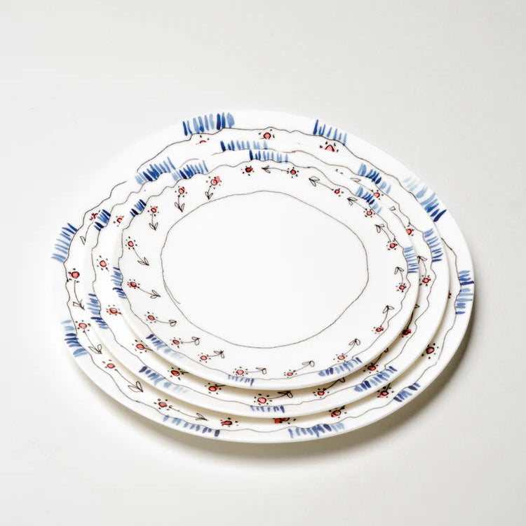 Set of three decorative ceramic plates with floral patterns on a white background