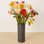 Vase with colorful flowers on a beige surface and white background