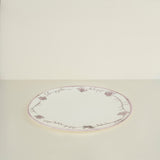 Round ceramic plate with floral patterns on a beige background