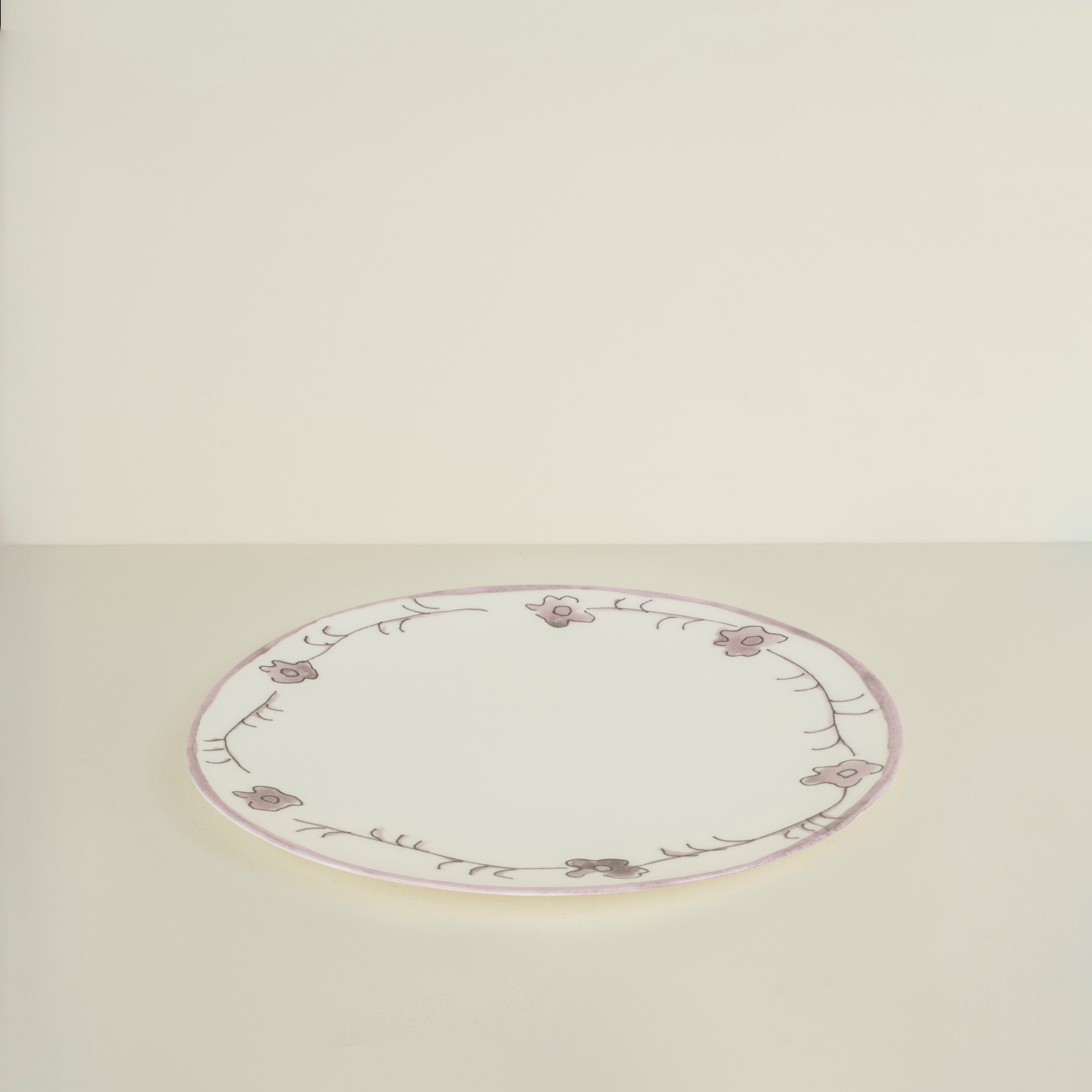 Round ceramic plate with floral patterns on a beige background