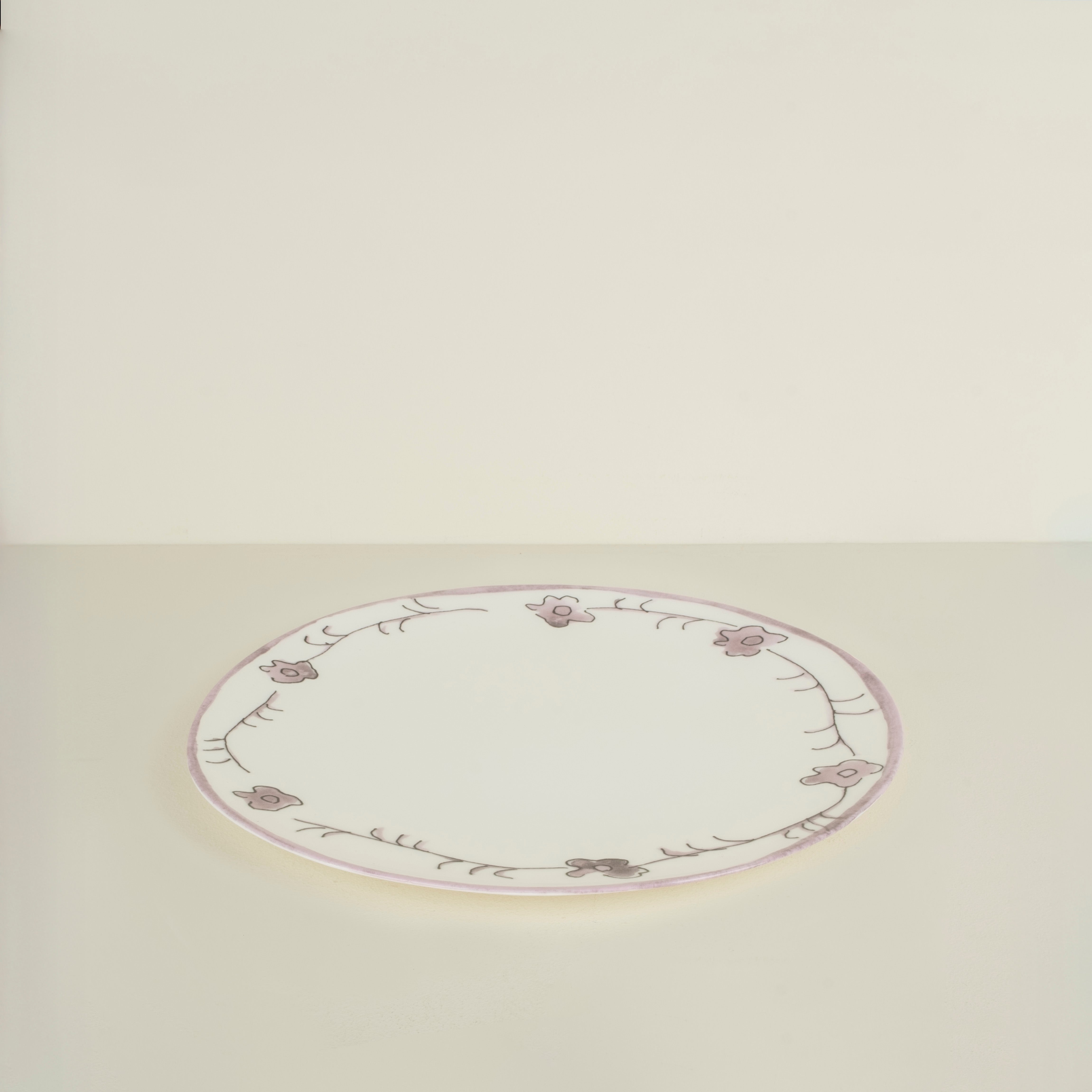 Round ceramic plate with floral patterns on a beige background
