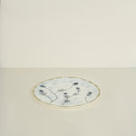 Round ceramic plate with floral design on a light beige background