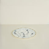 Round ceramic plate with floral design on a light beige background