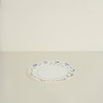 Oval ceramic platter with decorative rim on a beige background