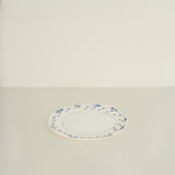 Oval ceramic platter with decorative rim on a beige background