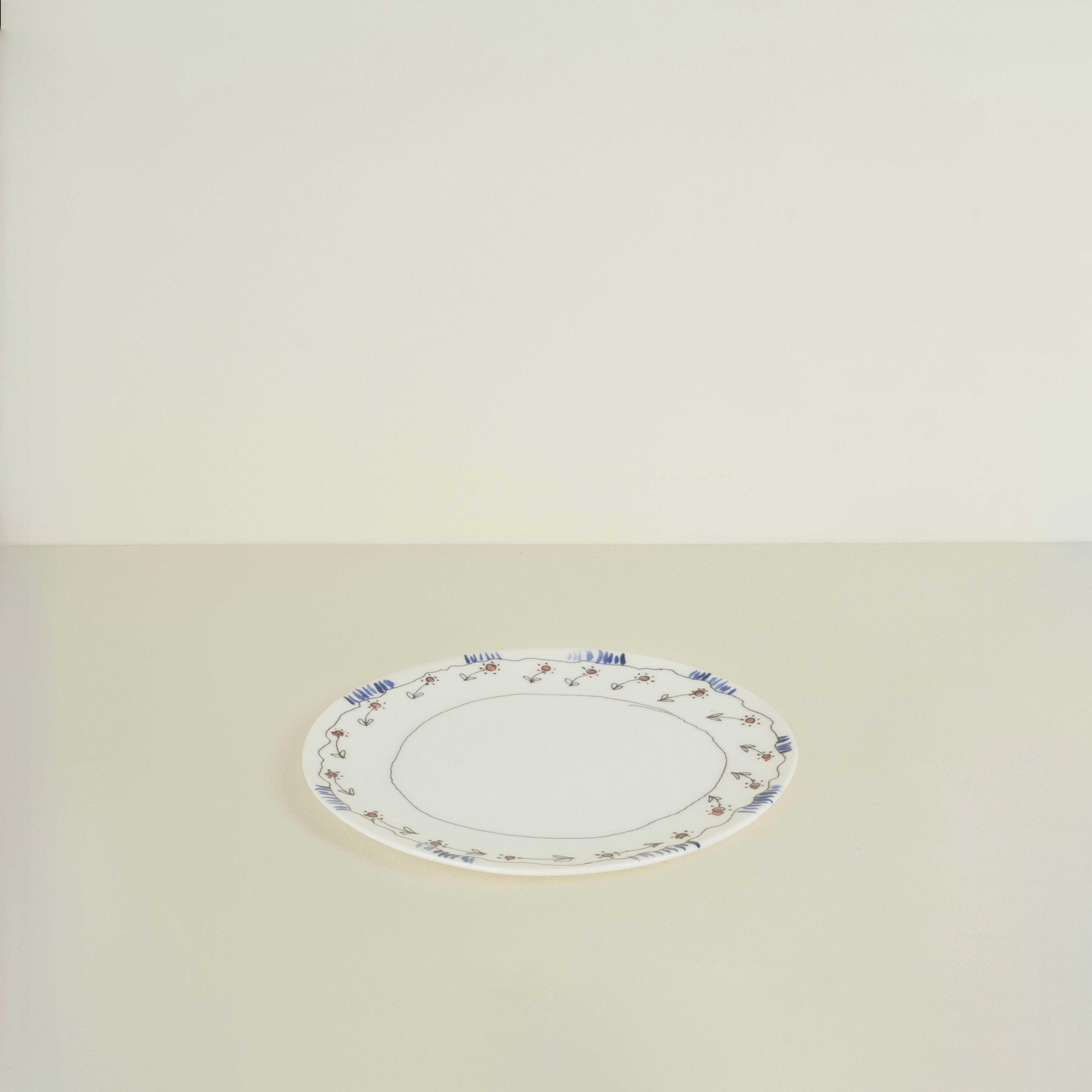 Oval ceramic platter with decorative rim on a beige background