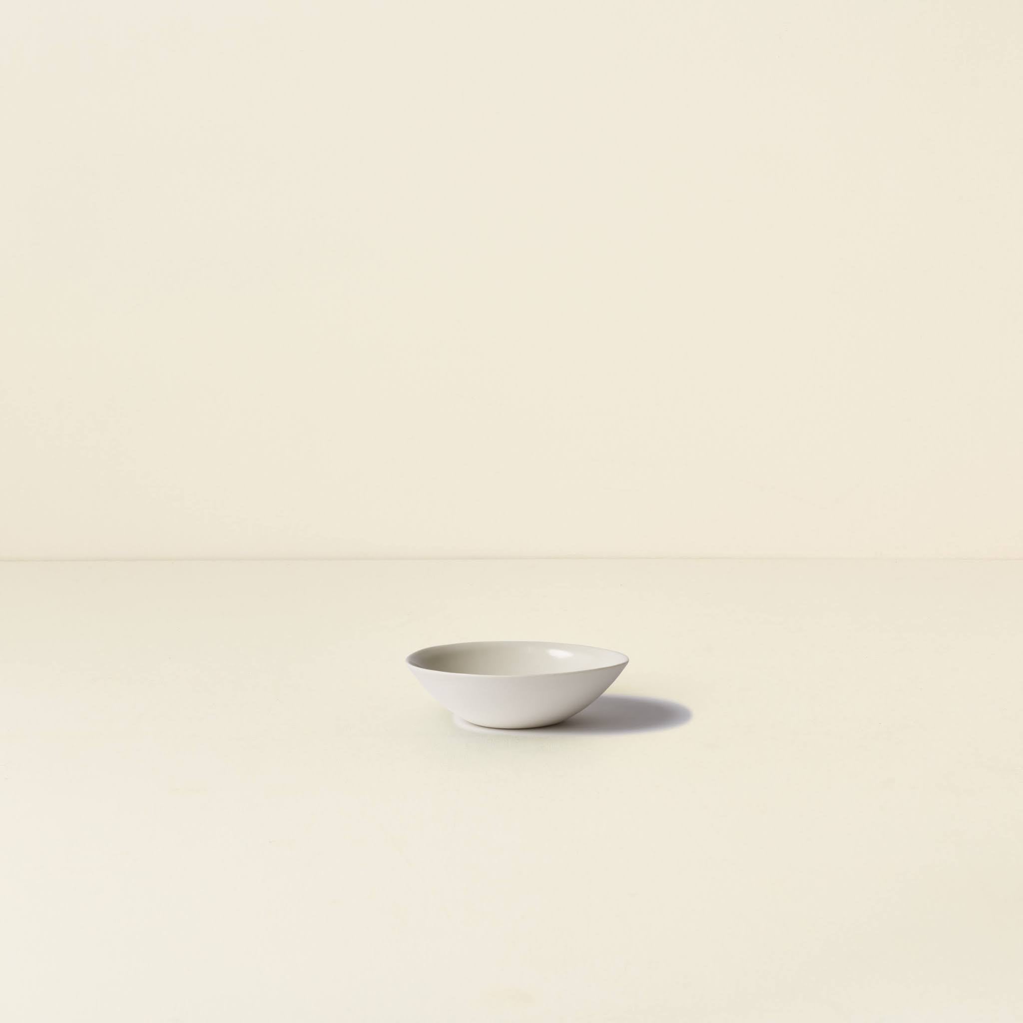 White ceramic bowl on a beige background